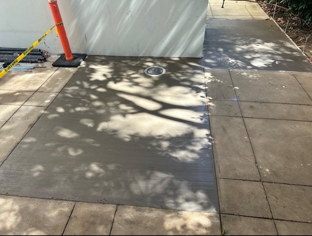 outdoor area with fresh concrete pour around roof drain