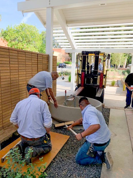 Teodoro Encizo, Gabriel Bueno from the Sheet Metal Shop and Randy Hill and George Hernandez from the Mason Shop are placing the basin after the concrete foundation had been poured