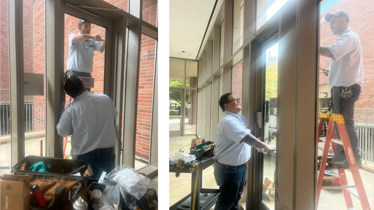 one man standing on the ground, and another man on an orange ladder working together to install new doors